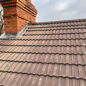 a roof with a brick chimney and a tiled roof