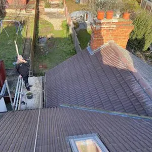 a man standing on a ladder on top of a roof